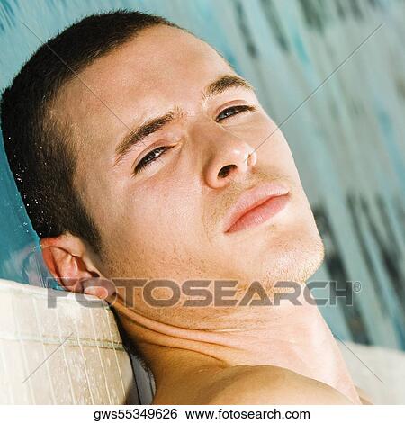 Close-up of a young man lying at the poolside View Large Photo Image Stock Photograph - Close-up of a young man lying at the poolside. Fotosearch