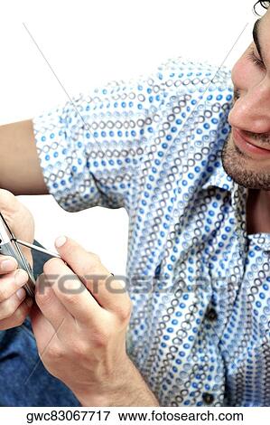 Stock Photo - Close-up of a young man operating a personal data assistant. Fotosearch