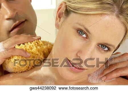 Close-up of a young man scrubbing a young woman's neck with a bath sponge View Large Photo Image Stock Image - Close-up of a young man scrubbing a young woman's neck with a bath sponge. Fotosearch