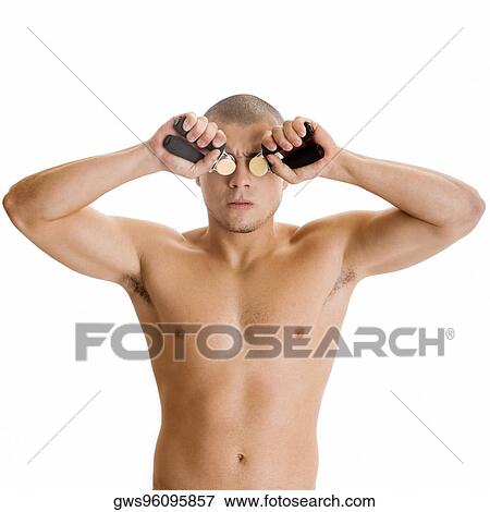 Stock Photo - Close-up of a young man squeezing handgrips in front of his eyes. Fotosearch