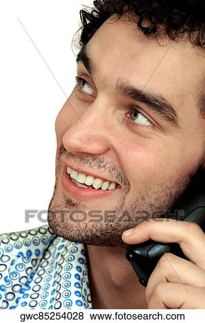 Close-up of a young man talking on a mobile phone View Large Photo Image Stock Photo - Close-up of a young man talking on a mobile phone. Fotosearch