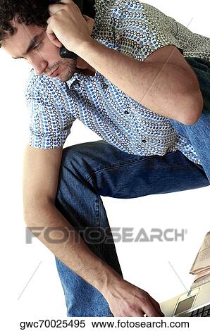 Stock Photography - Close-up of a young man talking on a mobile phone. Fotosearch