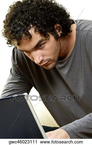 Close-up of a young man using a laptop View Large Photo Image Stock Image - Close-up of a young man using a laptop. Fotosearch