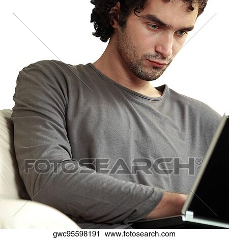 Close-up of a young man using a laptop View Large Photo Image Stock Image - Close-up of a young man using a laptop. Fotosearch