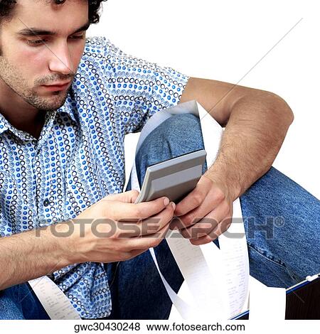 Close-up of a young man using a calculator View Large Photo Image Stock Photo - Close-up of a young man using a calculator. Fotosearch