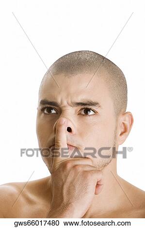 Stock Image - Close-up of a young man with his finger on his lips. Fotosearch