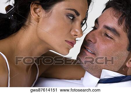 Close-up of a young woman and a mid adult man looking at each other View Large Photo Image Stock Image - Close-up of a young woman and a mid adult man looking at each other. Fotosearch