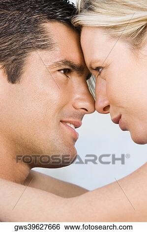 Close-up of a young woman and a mid adult man looking at each other View Large Photo Image Stock Photograph - Close-up of a young woman and a mid adult man looking at each other. Fotosearch