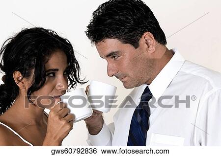 Close-up of a young woman and a mid adult man drinking coffee View Large Photo Image Stock Photograph - Close-up of a young woman and a mid adult man drinking coffee. Fotosearch