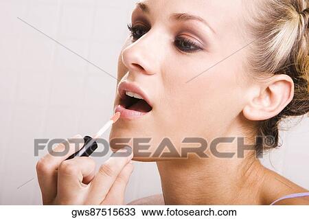 Close-up of a young woman applying lip liner View Large Photo Image Stock Image - Close-up of a young woman applying lip liner. Fotosearch
