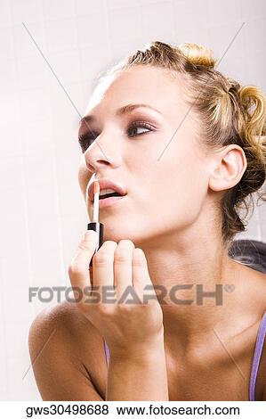 Close-up of a young woman applying lip liner View Large Photo Image Stock Photo - Close-up of a young woman applying lip liner. Fotosearch