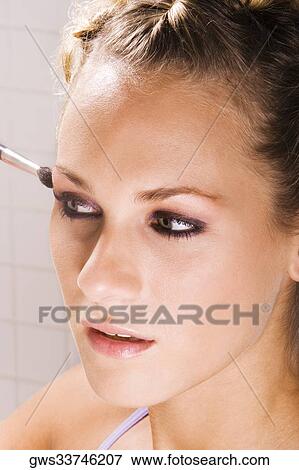 Close-up of a young woman applying eyeshadow View Large Photo Image Stock Photo - Close-up of a young woman applying eyeshadow. Fotosearch