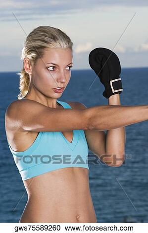 Stock Image - Close-up of a young woman boxing. Fotosearch