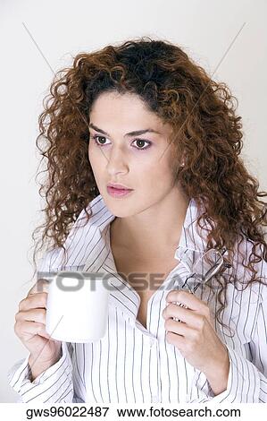 Close-up of a young woman holding a cup View Large Photo Image Stock Photo - Close-up of a young woman holding a cup. Fotosearch