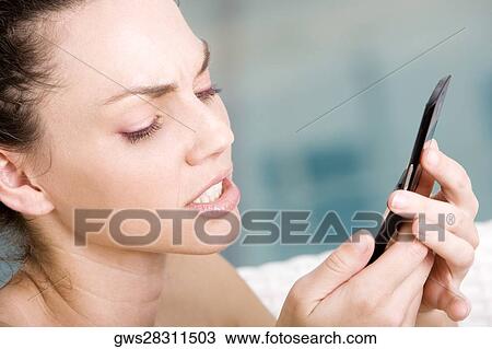 Close-up of a young woman holding a mobile phone View Large Photo Image Stock Image - Close-up of a young woman holding a mobile phone. Fotosearch