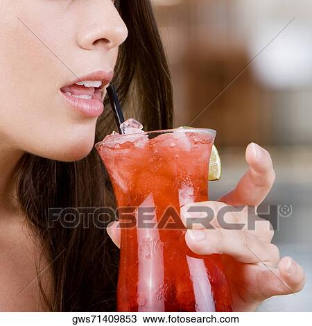 Close-up of a young woman holding a cocktail View Large Photo Image Stock Image - Close-up of a young woman holding a cocktail. Fotosearch