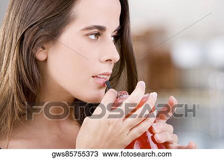 Close-up of a young woman holding a cocktail View Large Photo Image Stock Image - Close-up of a young woman holding a cocktail. Fotosearch