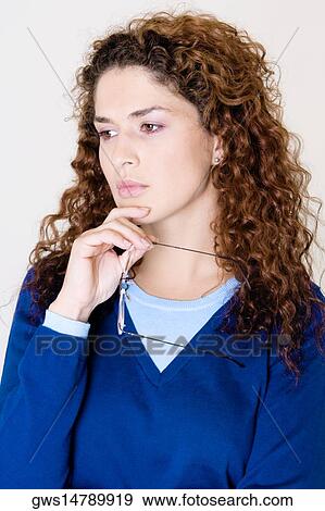 Close-up of a young woman holding her eyeglasses View Large Photo Image Stock Photo - Close-up of a young woman holding her eyeglasses. Fotosearch