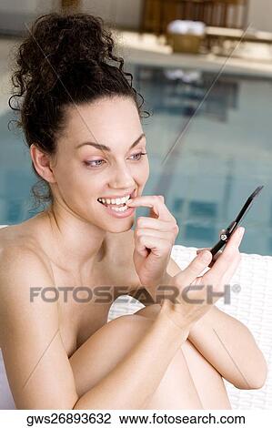 Close-up of a young woman looking at a mobile phone View Large Photo Image Stock Image - Close-up of a young woman looking at a mobile phone. Fotosearch