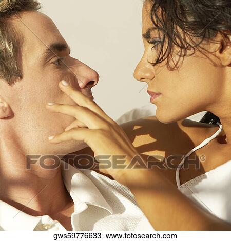 Close-up of a young woman looking at a young man View Large Photo Image Stock Image - Close-up of a young woman looking at a young man. Fotosearch