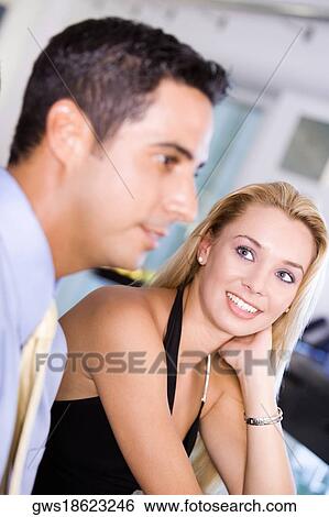 Close-up of a young woman looking at a mid adult man View Large Photo Image Stock Photograph - Close-up of a young woman looking at a mid adult man. Fotosearch