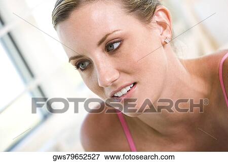 Close-up of a young woman looking away View Large Photo Image Stock Photo - Close-up of a young woman looking away. Fotosearch