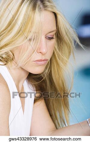 Close-up of a young woman looking down View Large Photo Image Stock Photograph - Close-up of a young woman looking down. Fotosearch