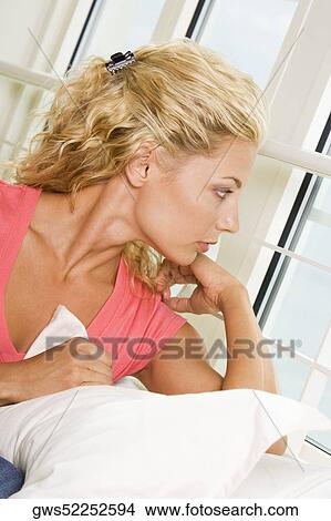 Close-up of a young woman looking out of a window View Large Photo Image Picture - Close-up of a young woman looking out of a window. Fotosearch
