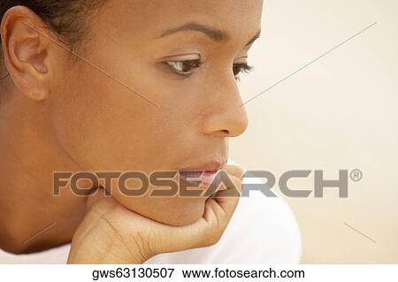 Close-up of a young woman looking sad View Large Photo Image Stock Photo - Close-up of a young woman looking sad. Fotosearch