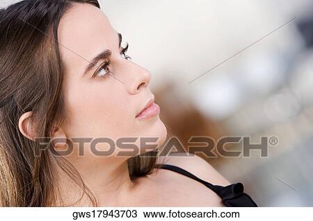Close-up of a young woman looking sideways View Large Photo Image Stock Image - Close-up of a young woman looking sideways. Fotosearch