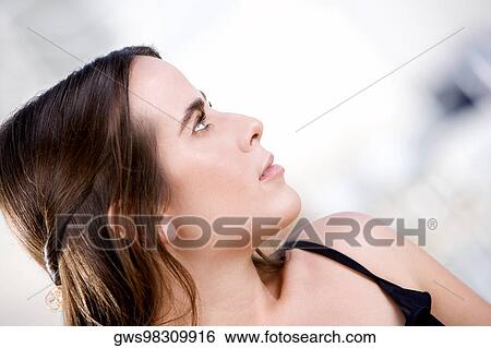 Close-up of a young woman looking sideways View Large Photo Image Stock Photograph - Close-up of a young woman looking sideways. Fotosearch