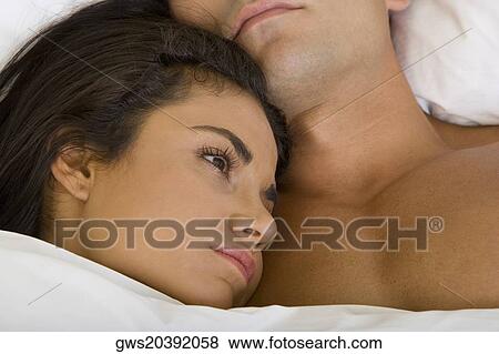 Close-up of a young woman lying down with her head on a young man's chest View Large Photo Image Stock Photo - Close-up of a young woman lying down with her head on a young man's chest. Fotosearch