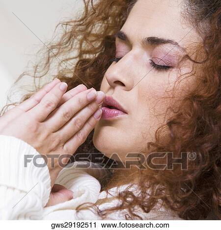Stock Image - Close-up of a young woman praying. Fotosearch