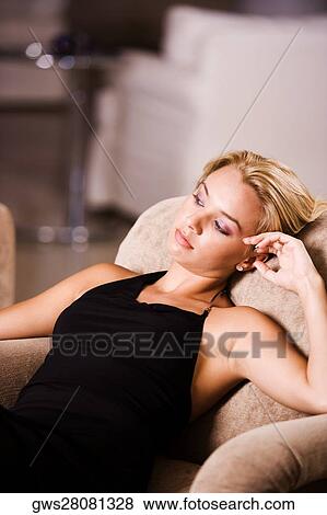 Close-up of a young woman reclining on an armchair View Large Photo Image Stock Photo - Close-up of a young woman reclining on an armchair. Fotosearch