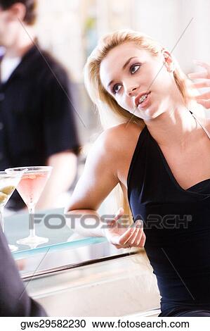 Close-up of a young woman sitting at a bar counter View Large Photo Image Stock Image - Close-up of a young woman sitting at a bar counter. Fotosearch