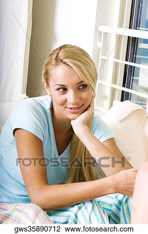 Close-up of a young woman sitting with her hand on her chin View Large Photo Image Stock Image - Close-up of a young woman sitting with her hand on her chin. Fotosearch