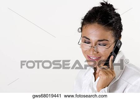 Close-up of a young woman talking on a mobile phone View Large Photo Image Stock Image - Close-up of a young woman talking on a mobile phone. Fotosearch
