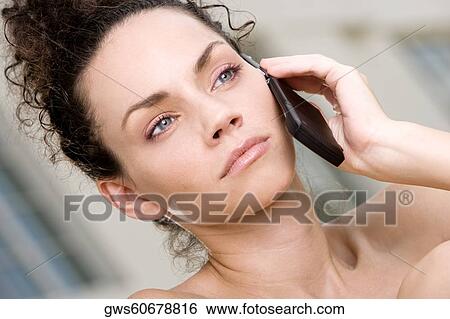 Stock Photograph - Close-up of a young woman talking on a mobile phone. Fotosearch