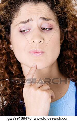 Close-up of a young woman thinking View Large Photo Image Stock Image - Close-up of a young woman thinking. Fotosearch