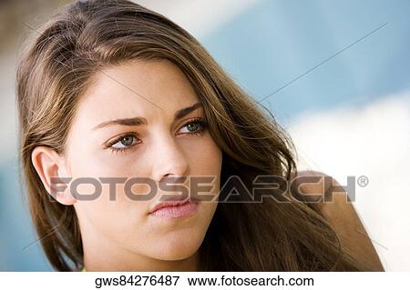 Close-up of a young woman thinking View Large Photo Image Stock Photo - Close-up of a young woman thinking. Fotosearch