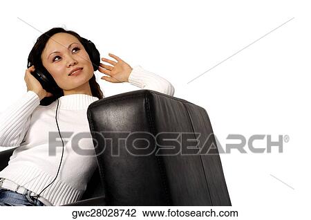 Close-up of a young woman wearing headphones listening to music View Large Photo Image Stock Image - Close-up of a young woman wearing headphones listening to music. Fotosearch