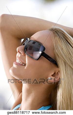 Stock Photo - Close-up of a young woman wearing sunglasses. Fotosearch