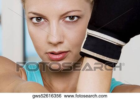 Close-up of a young woman wearing boxing gloves View Large Photo Image Stock Photograph - Close-up of a young woman wearing boxing gloves. Fotosearch
