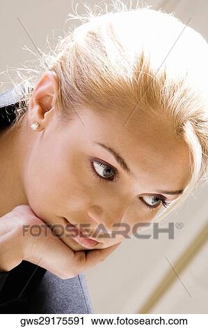 Close-up of a young woman with her hand on her chin View Large Photo Image Stock Image - Close-up of a young woman with her hand on her chin. Fotosearch