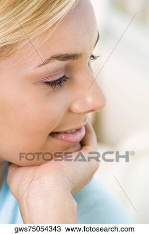 Stock Image - Close-up of a young woman with her hand on her chin. Fotosearch