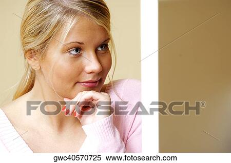 Stock Photography - Close-up of a young woman with her hand on her chin. Fotosearch