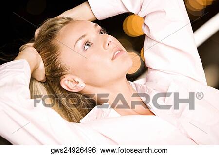 Close-up of a young woman with her hands on her head View Large Photo Image Stock Photograph - Close-up of a young woman with her hands on her head. Fotosearch