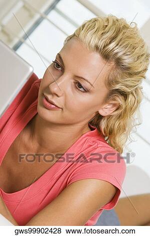 Close-up of a young woman working on a laptop View Large Photo Image Stock Photo - Close-up of a young woman working on a laptop. Fotosearch