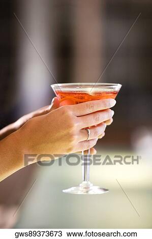 Close-up of a young woman's hand holding a glass of martini View Large Photo Image Stock Image - Close-up of a young woman's hand holding a glass of martini. Fotosearch