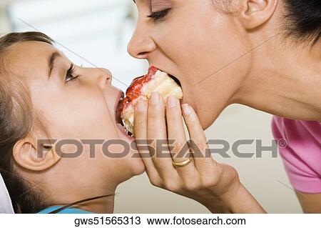 Close-up of mother sharing a pastry with her daughter View Large Photo Image Stock Image - Close-up of mother sharing a pastry with her daughter. Fotosearch